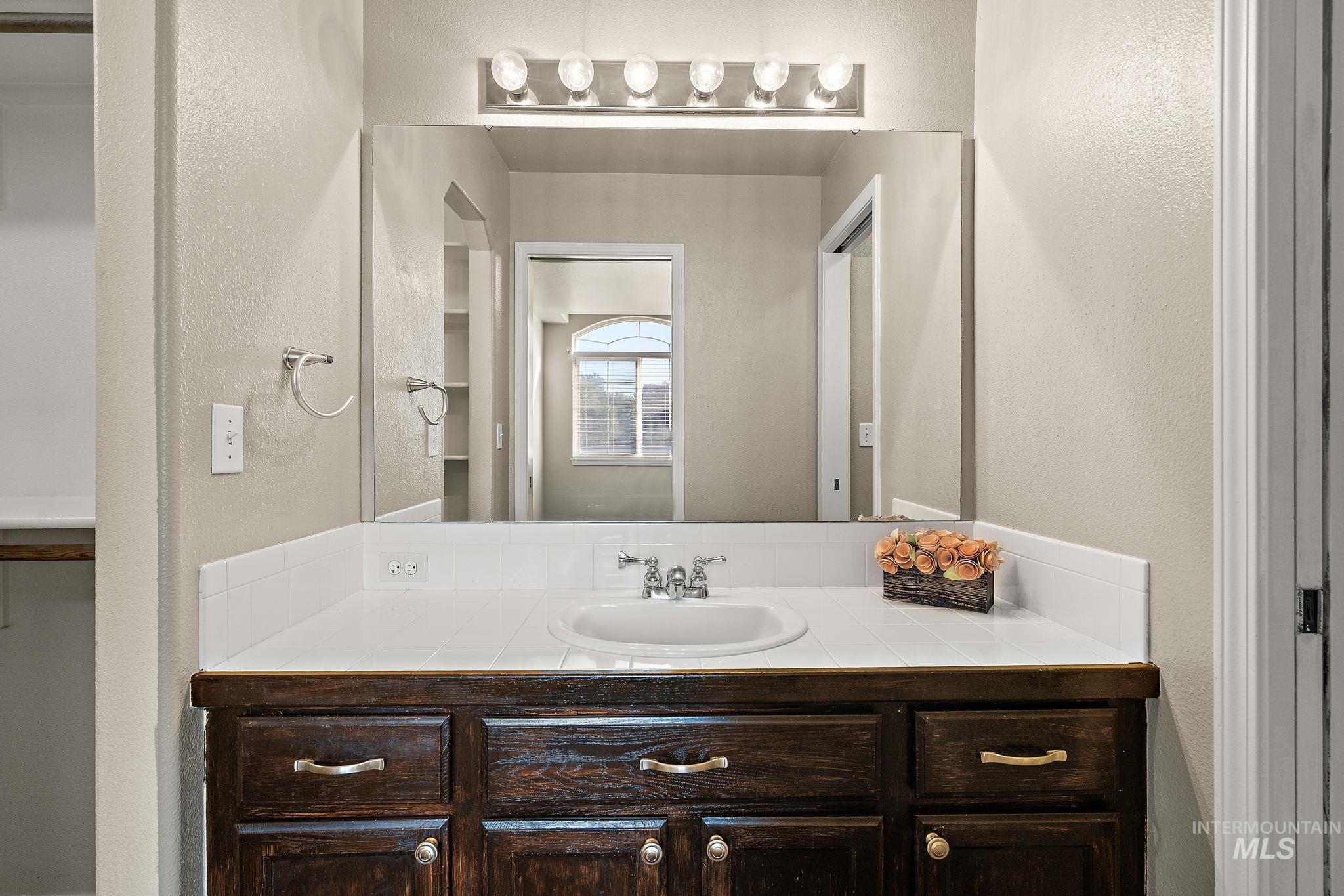 Bathroom with a textured wall and vanity