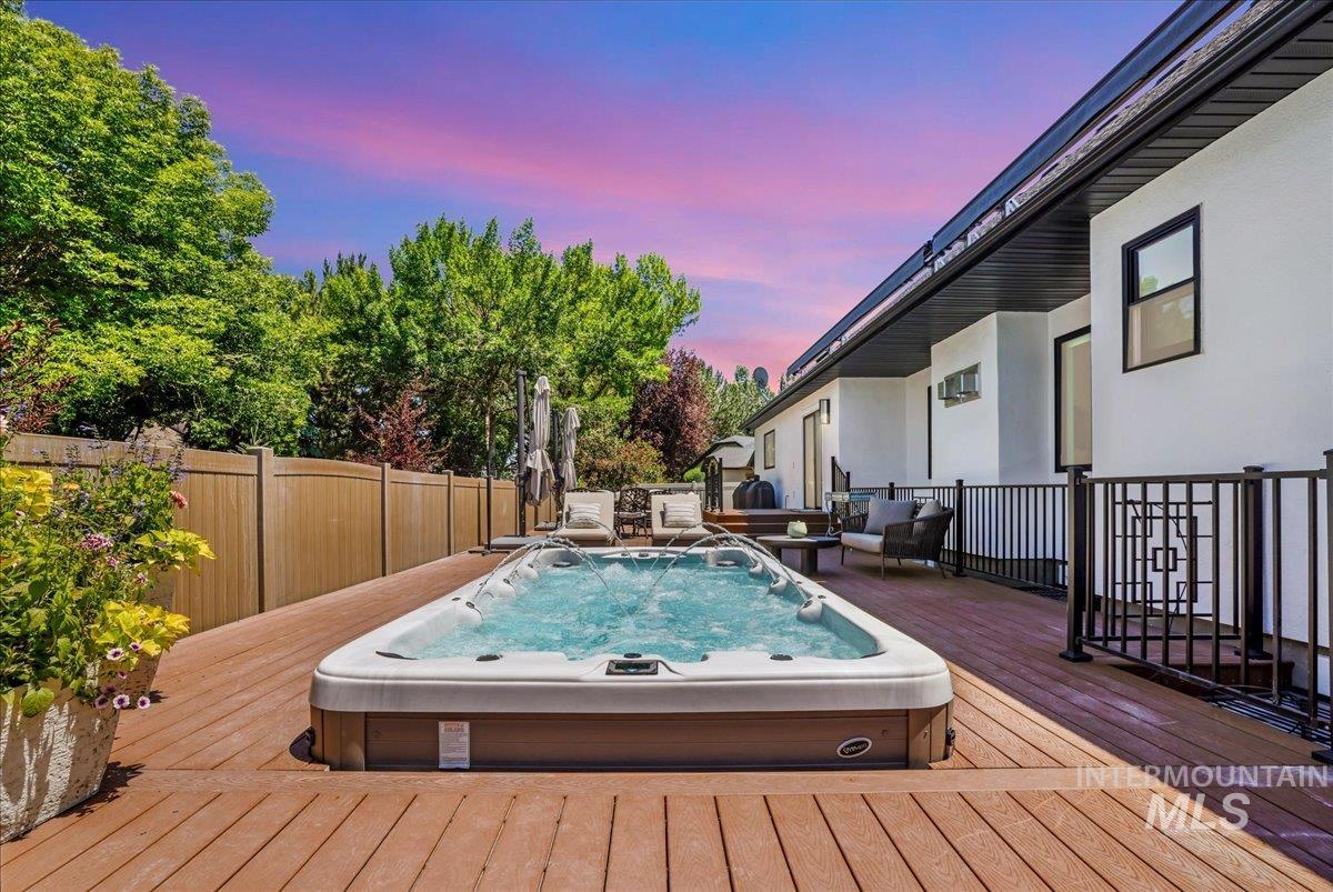 Pool at dusk featuring a wooden deck and an outdoor living space