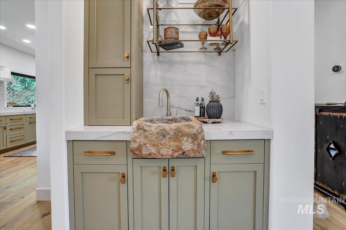 Bar with light wood-type flooring and recessed lighting