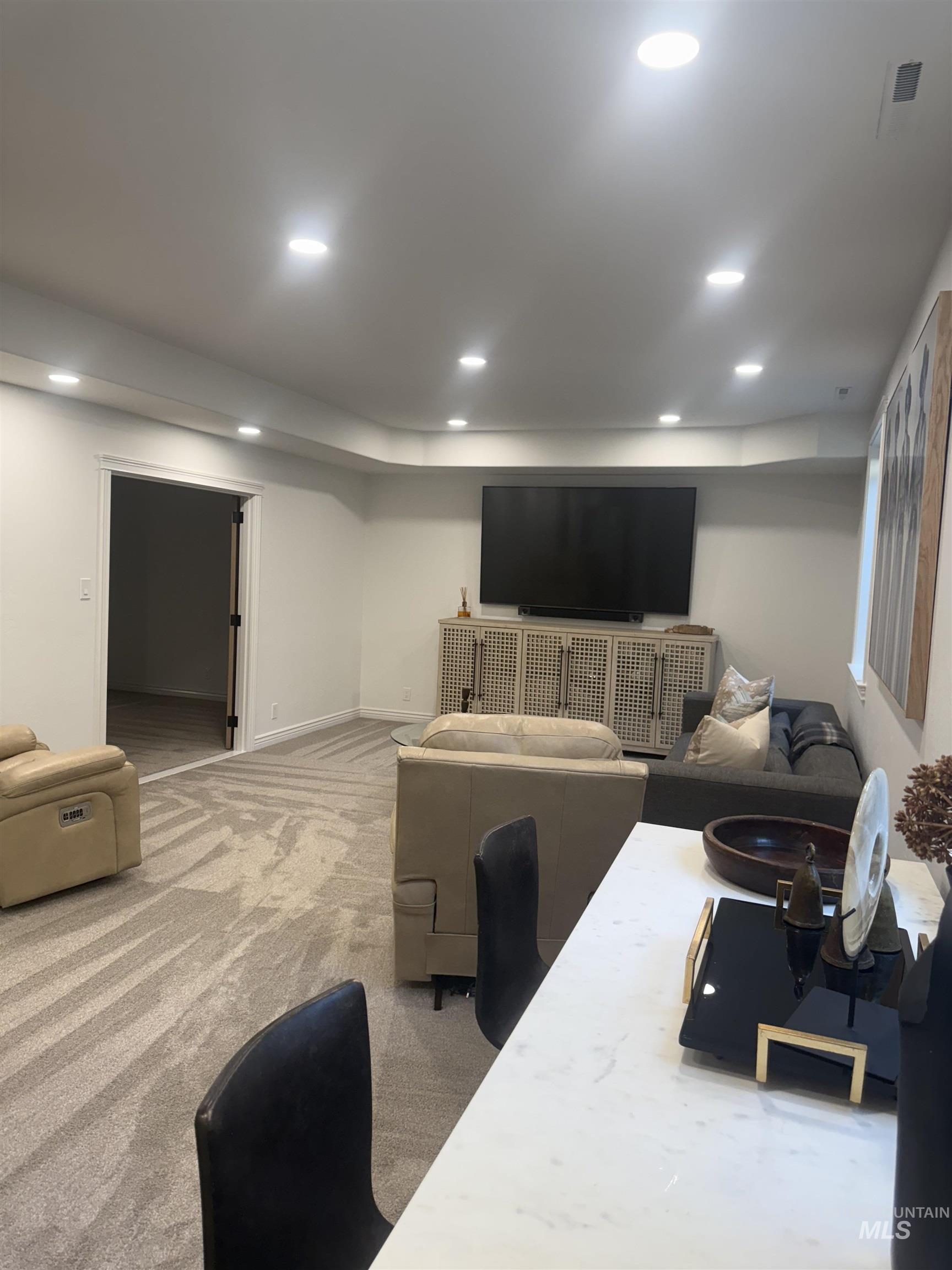 Living area with recessed lighting and light colored carpet