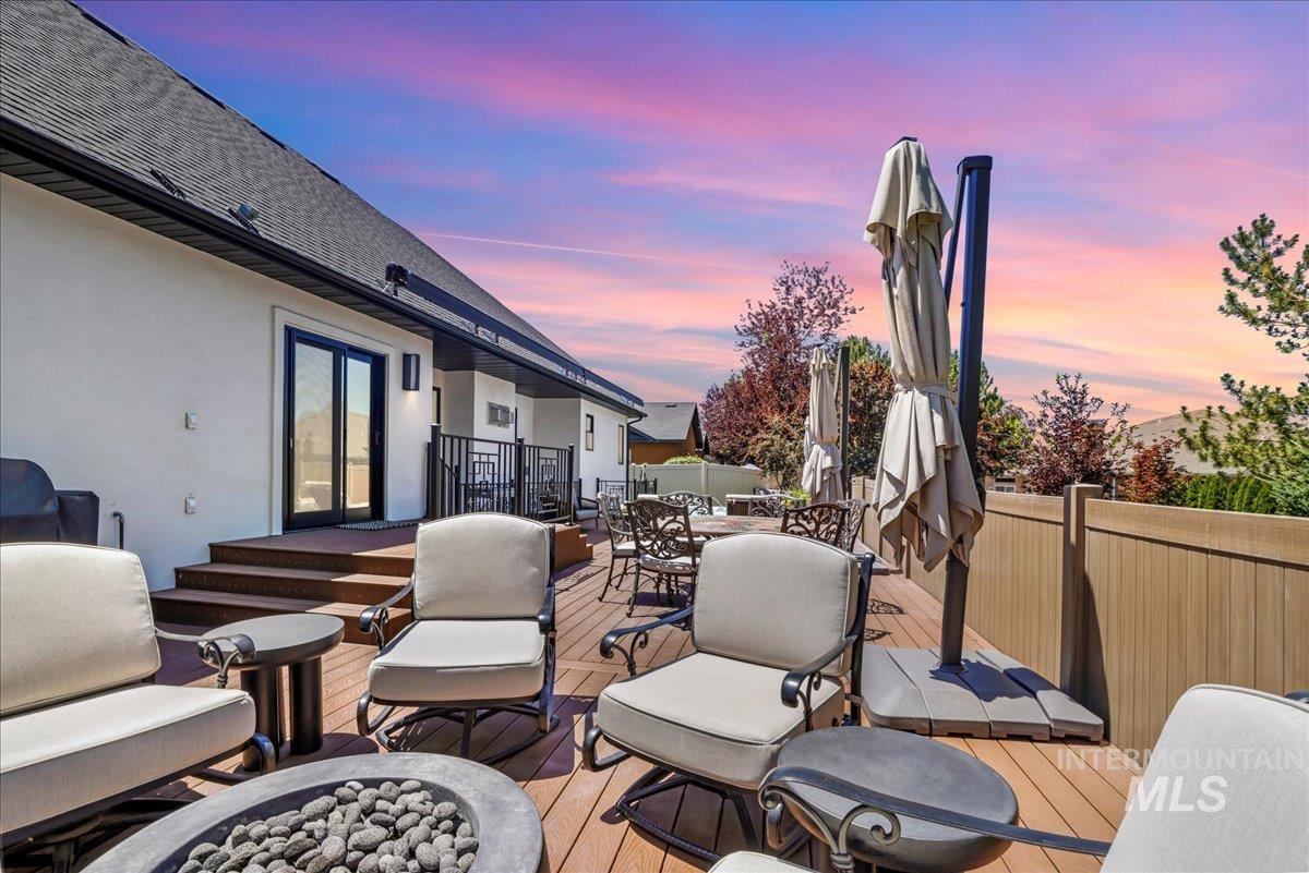 Deck at dusk with outdoor dining area, an outdoor fire pit, and french doors