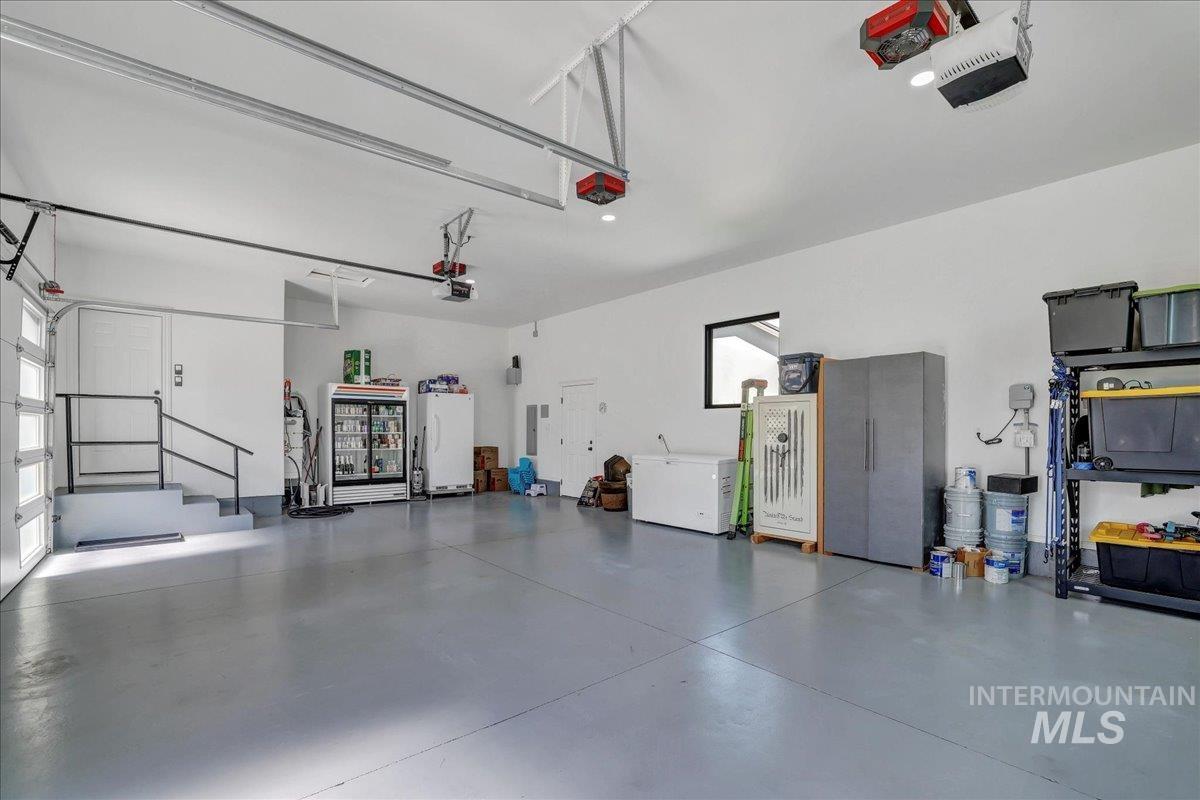 Garage featuring freestanding refrigerator and a garage door opener