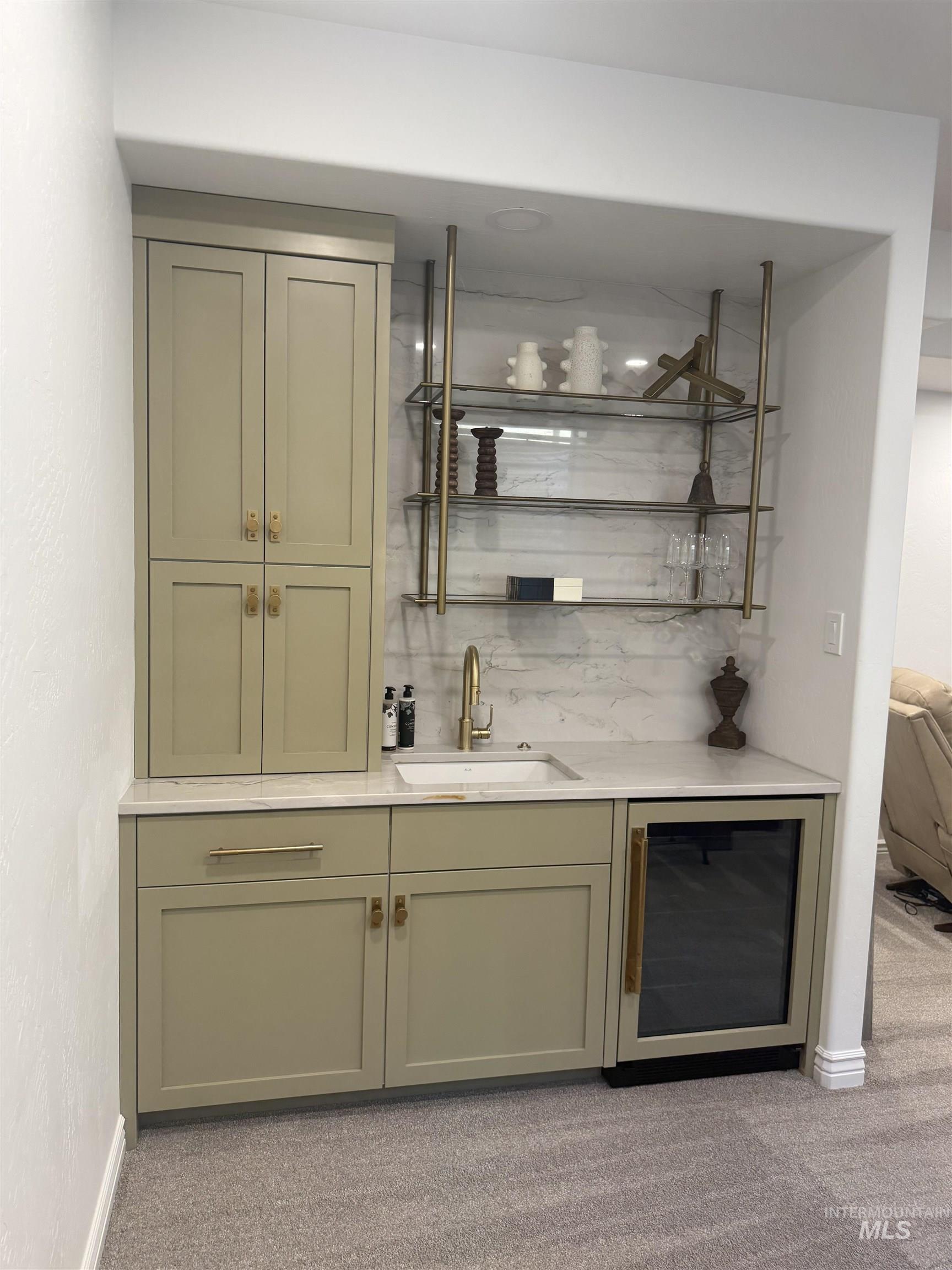 Indoor wet bar featuring wine cooler, open shelves, light colored carpet, light stone countertops, and backsplash