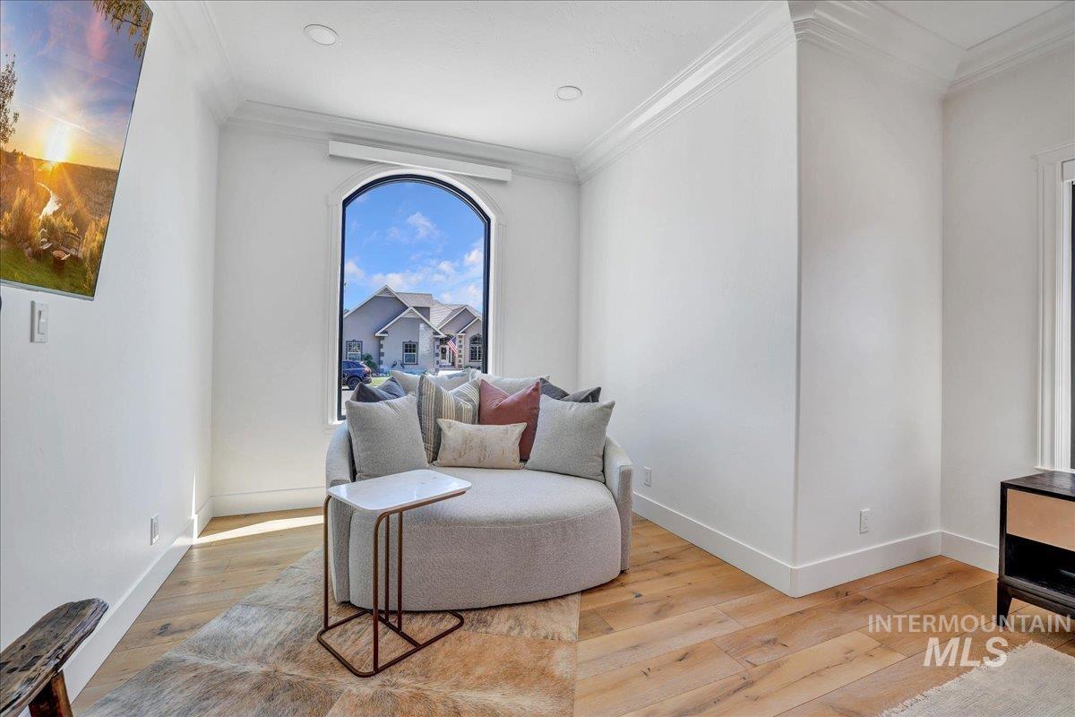 Sitting room with ornamental molding and hardwood / wood-style flooring