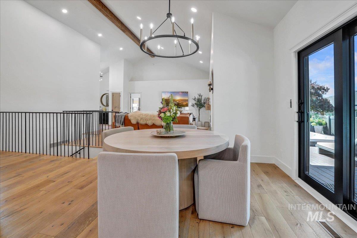 Dining room with beam ceiling, light wood-style floors, a chandelier, recessed lighting, and high vaulted ceiling