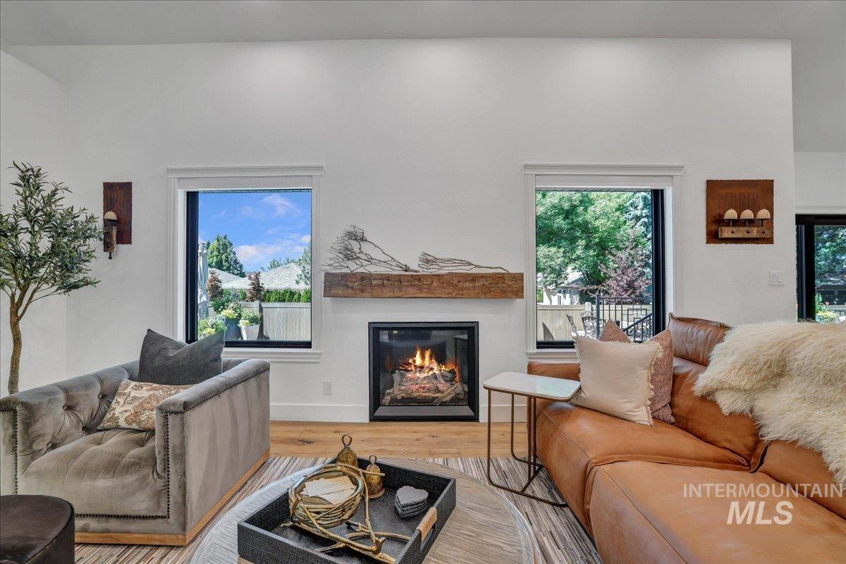 Living area with wood finished floors and a glass covered fireplace