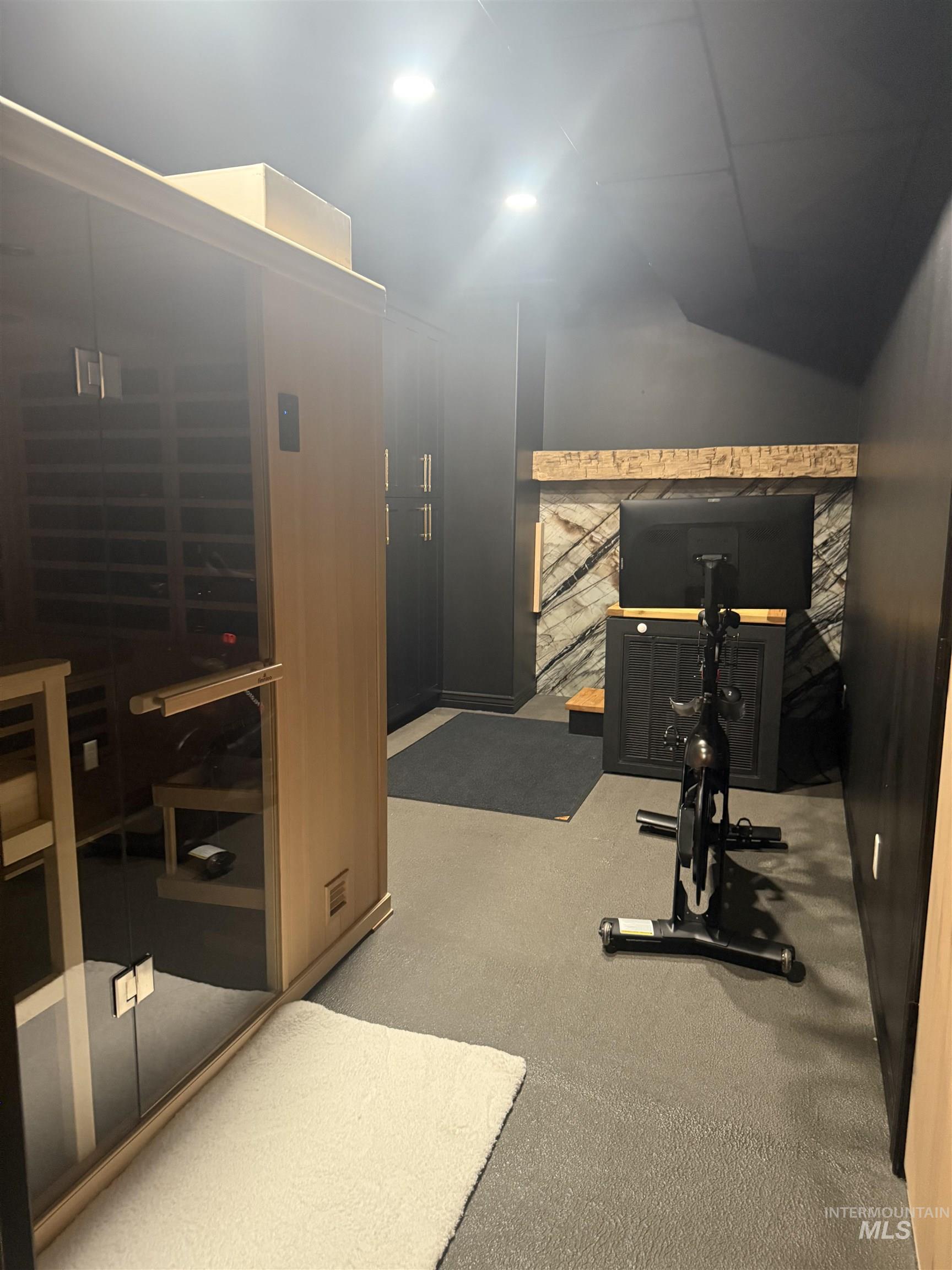 Workout room with vaulted ceiling, light colored carpet, and recessed lighting