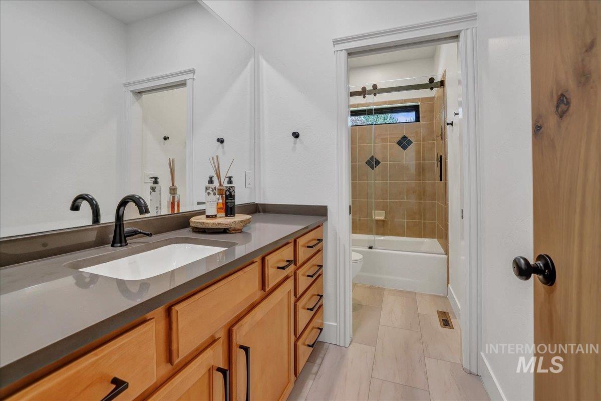 Full bath featuring vanity and enclosed tub / shower combo
