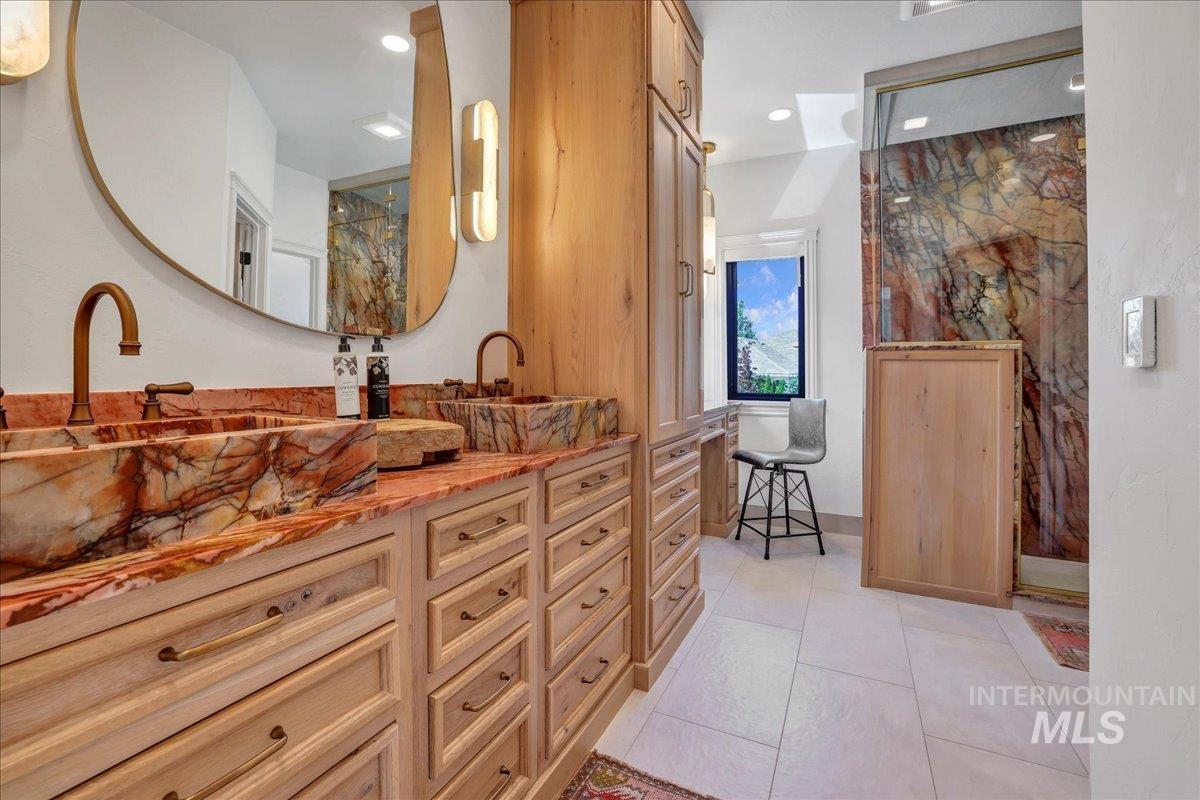 Full bath featuring vanity, a marble finish shower, tile patterned floors, and recessed lighting
