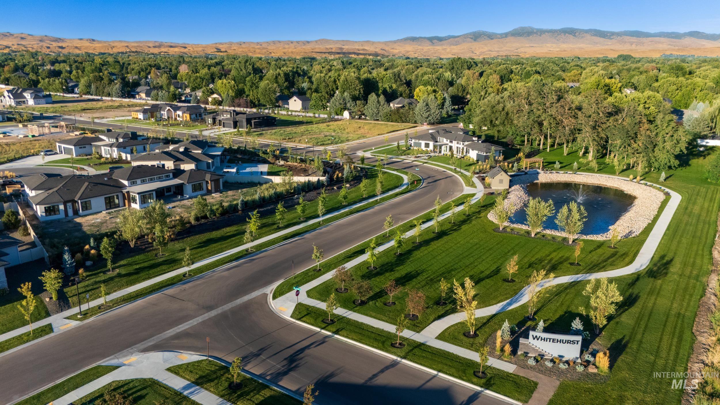 View of property location featuring a forest and a nearby body of water