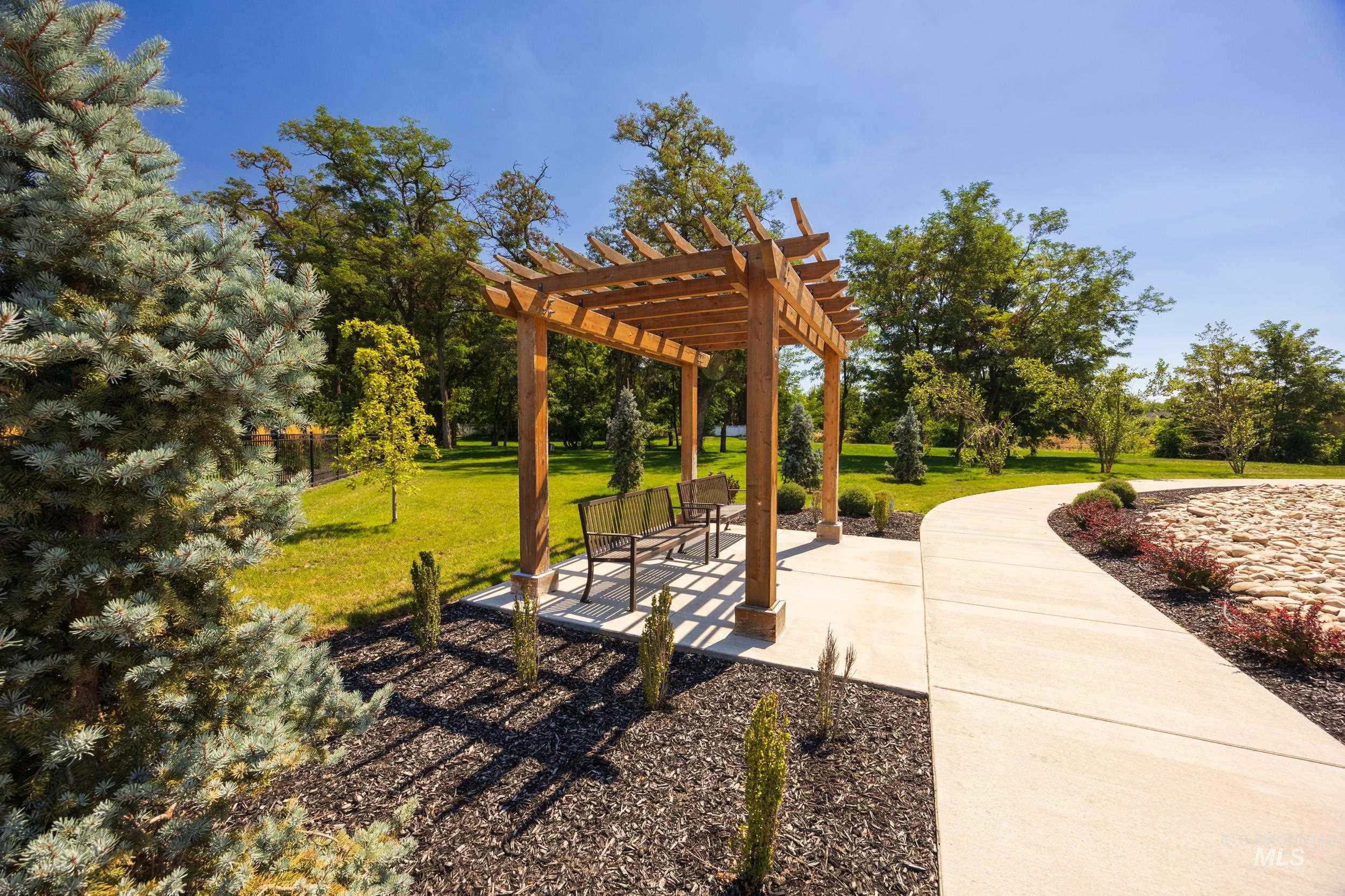 View of property's community with a pergola, a lawn, and a patio