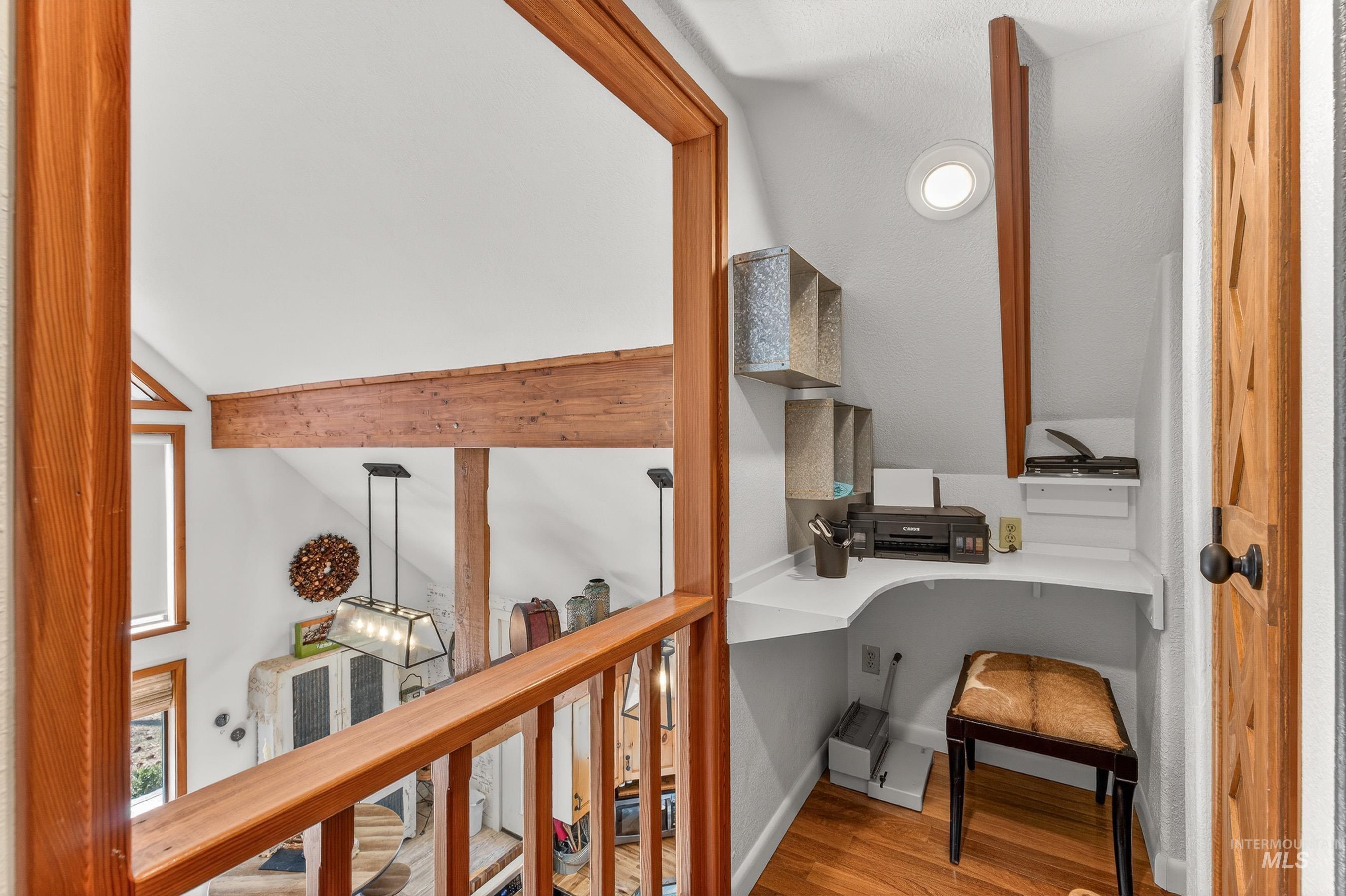 Built-in desk nook featuring a white countertop and wood-finish flooring
