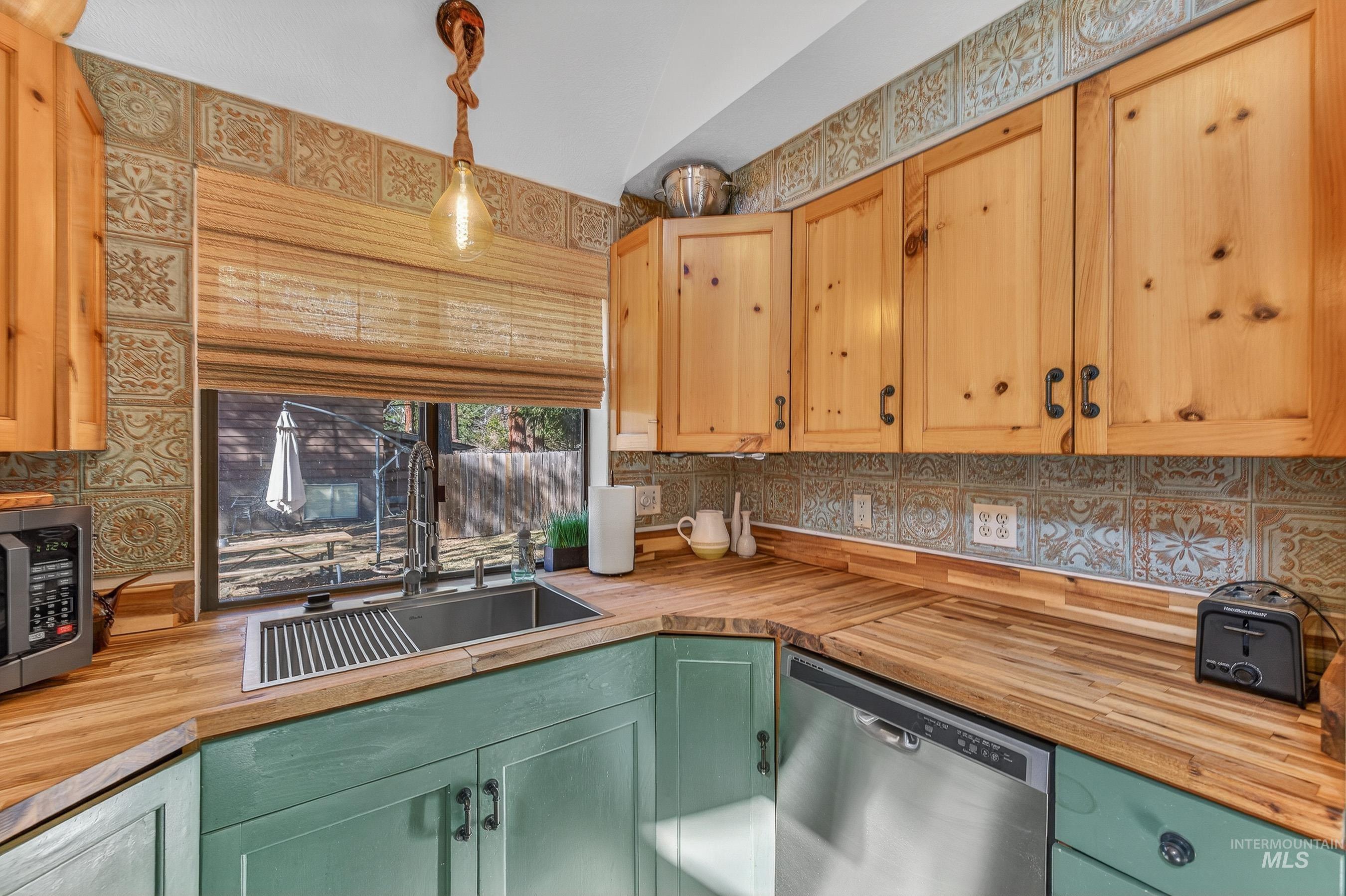 Kitchen featuring wood-finish countertops, stainless steel sink, and wood cabinetry