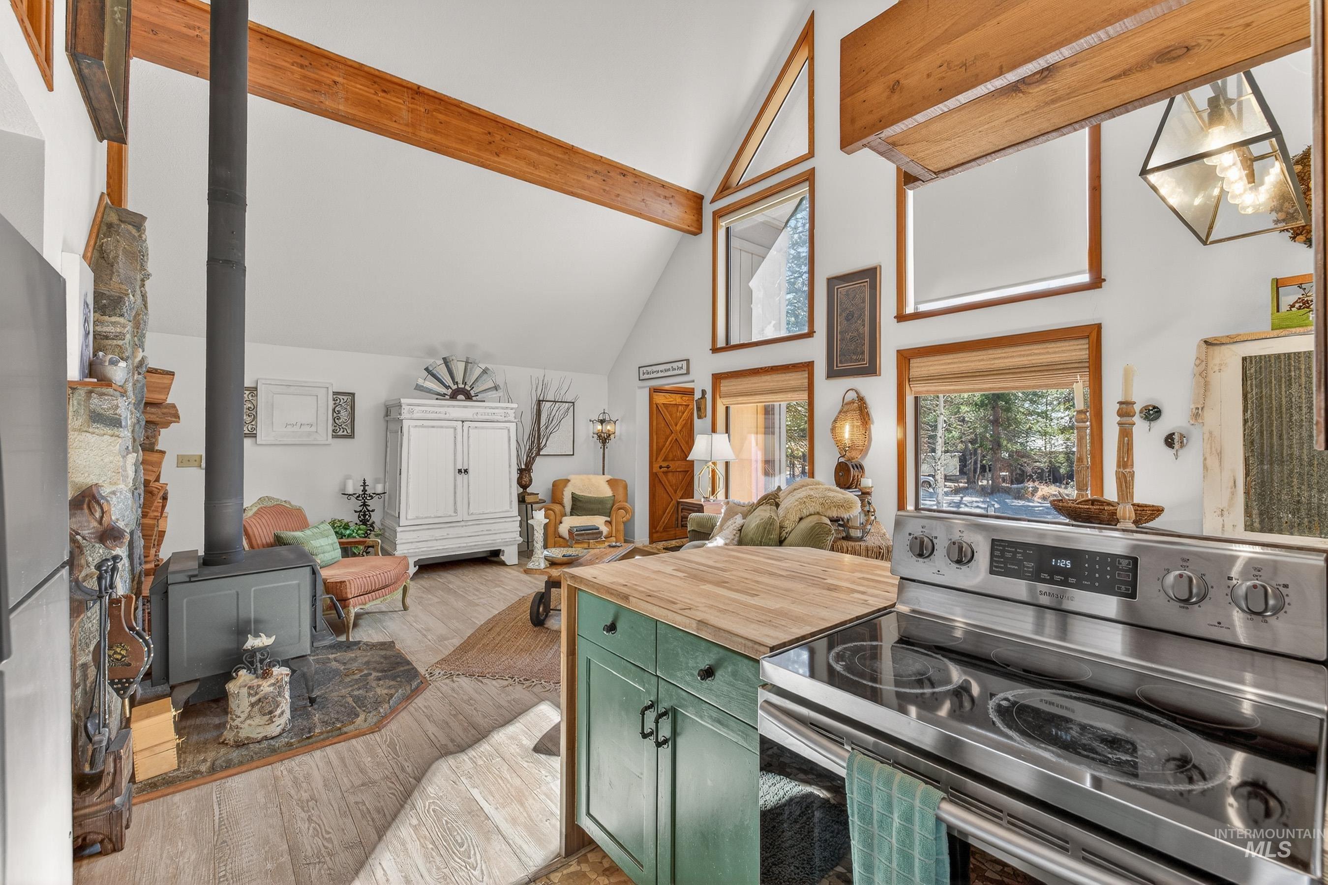 Open-concept living space with vaulted ceilings and exposed wood beams