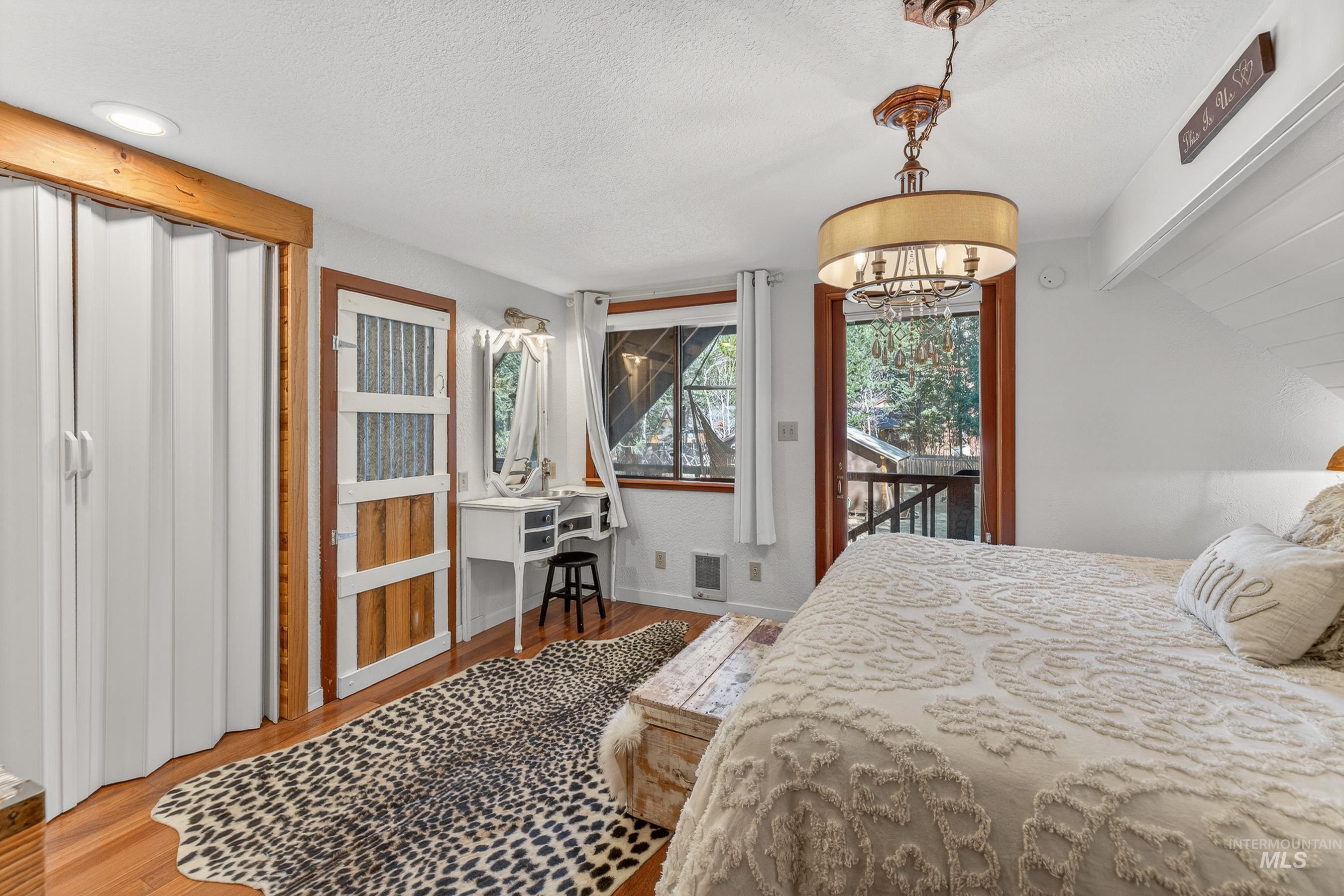 Hardwood-finish flooring with white walls and a sloped ceiling