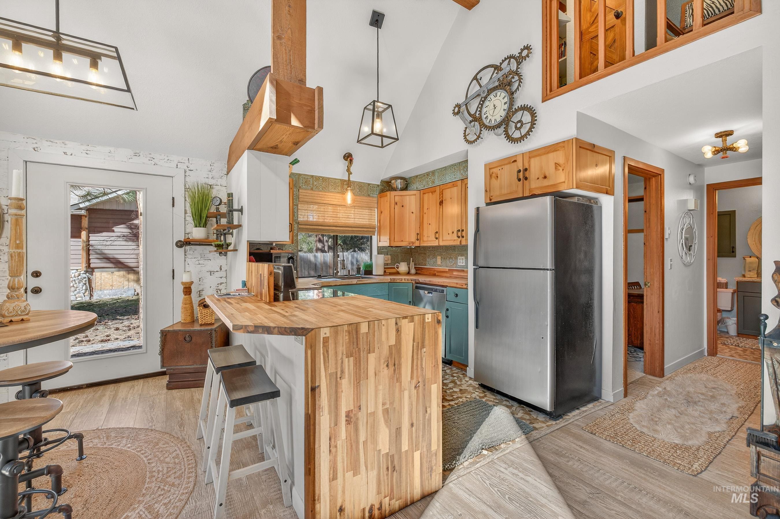Kitchen featuring a wood-finish island with seating, a stainless steel refrigerator, and wood-finish cabinetry