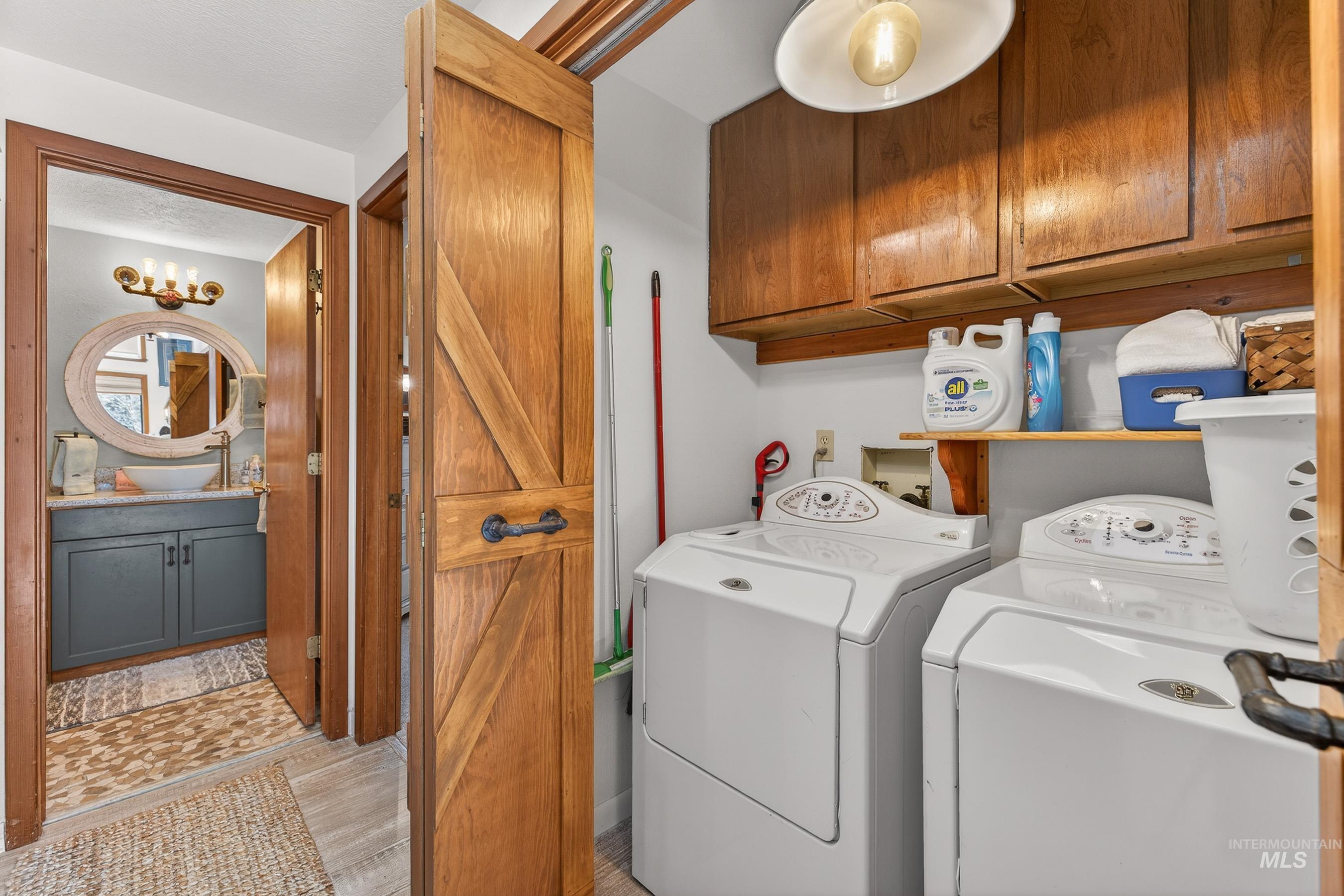 Dedicated laundry area with upper wood cabinetry and shelving