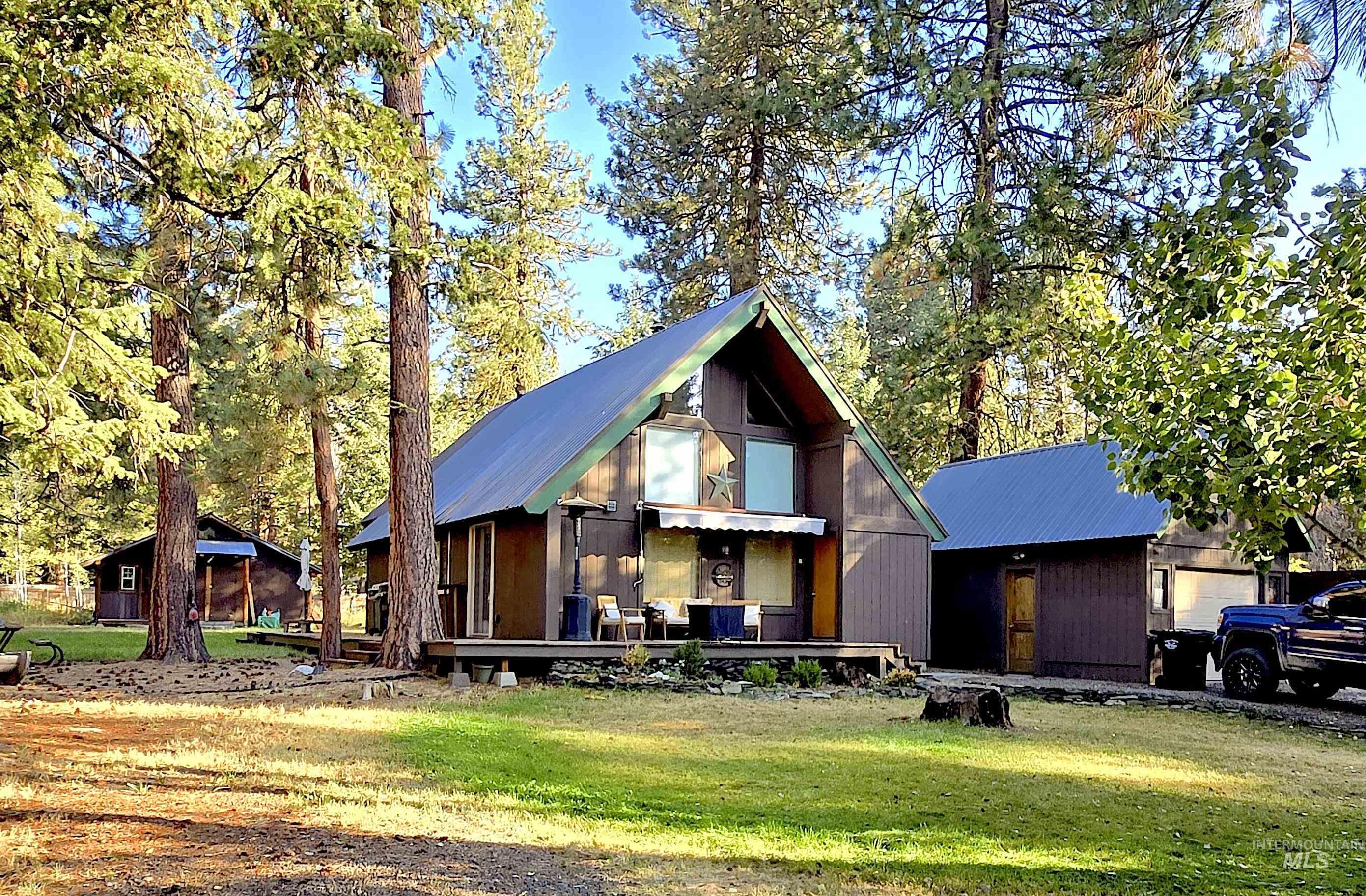 Chalet / cabin with a front yard and a metal roof
