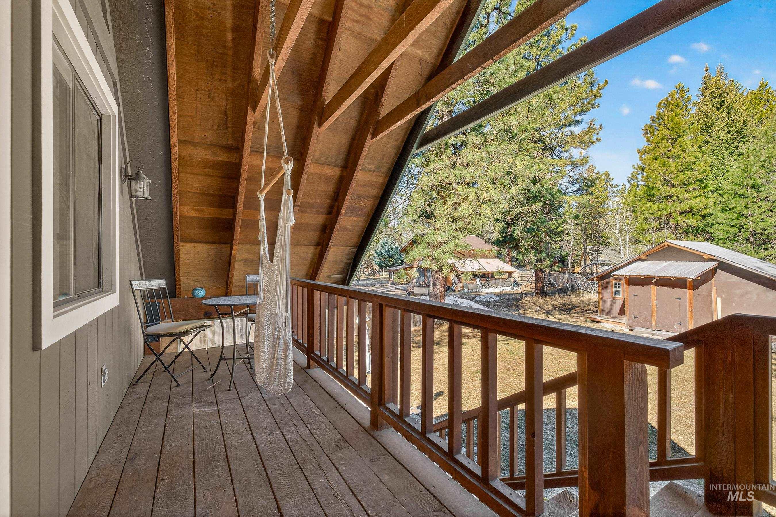 Exterior balcony featuring wood plank flooring and a wood railing