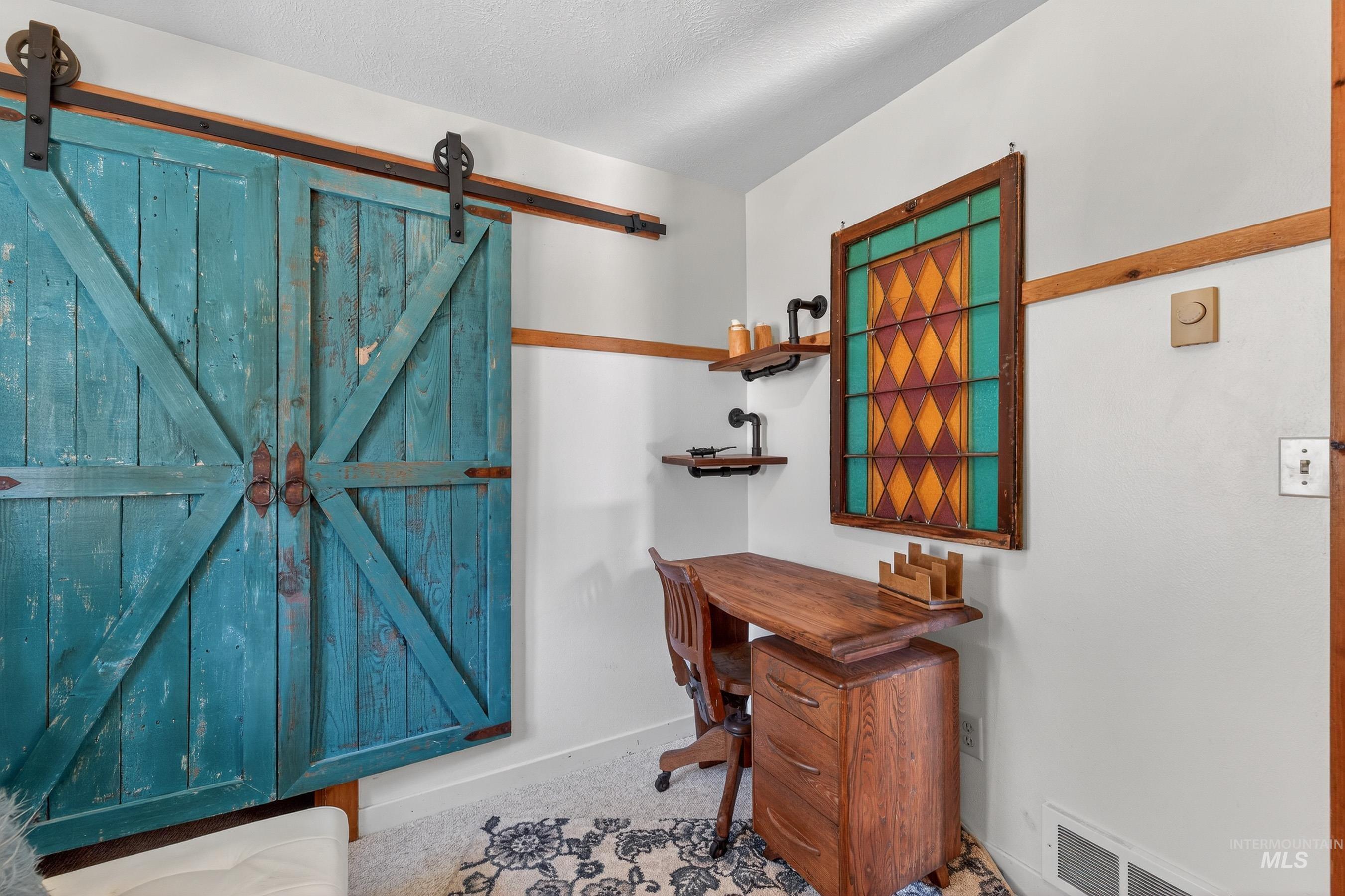 Barn door entry featuring a distressed teal finish and black metal hardware