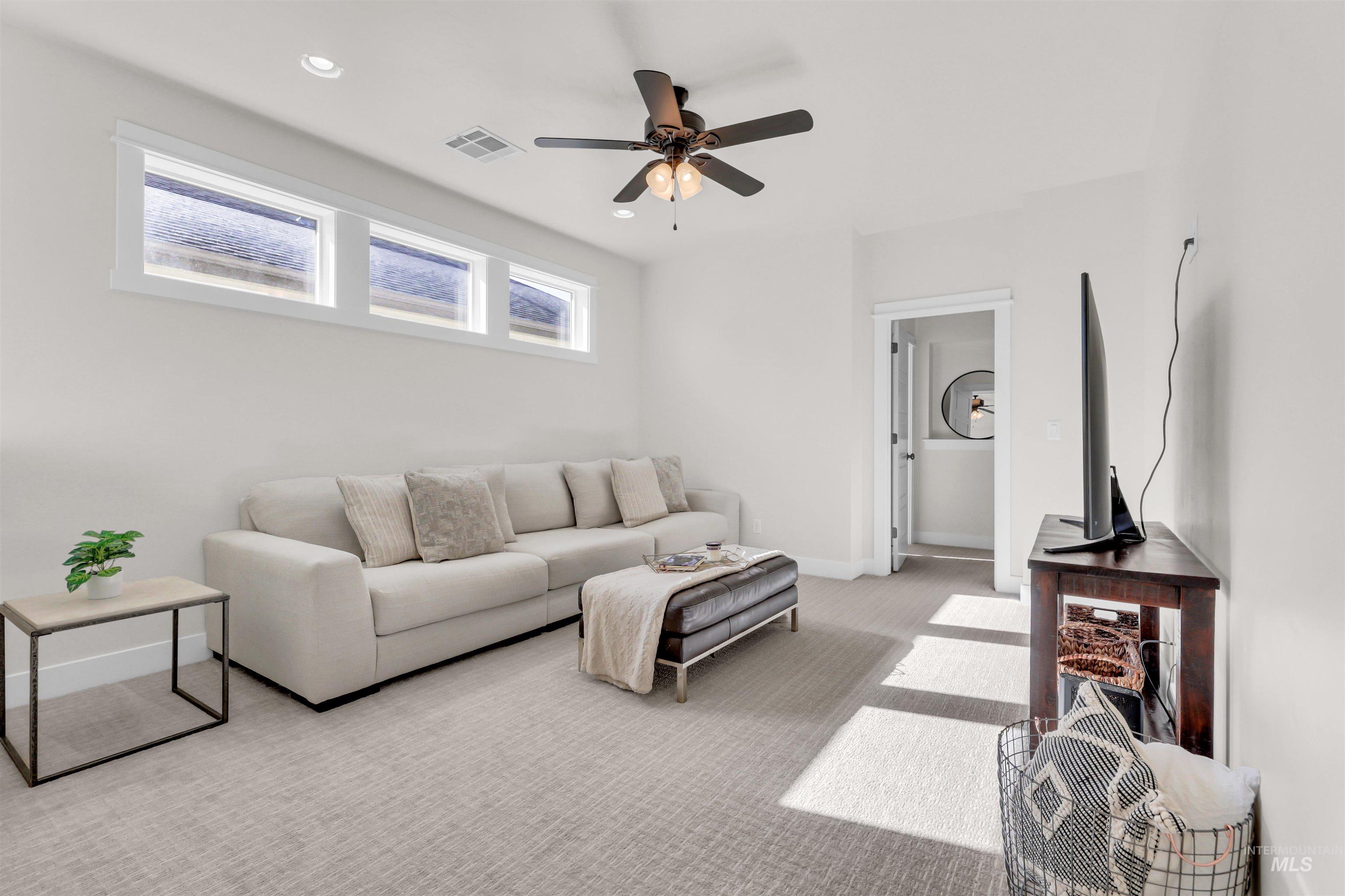 Living room featuring light colored carpet, a ceiling fan, and recessed lighting