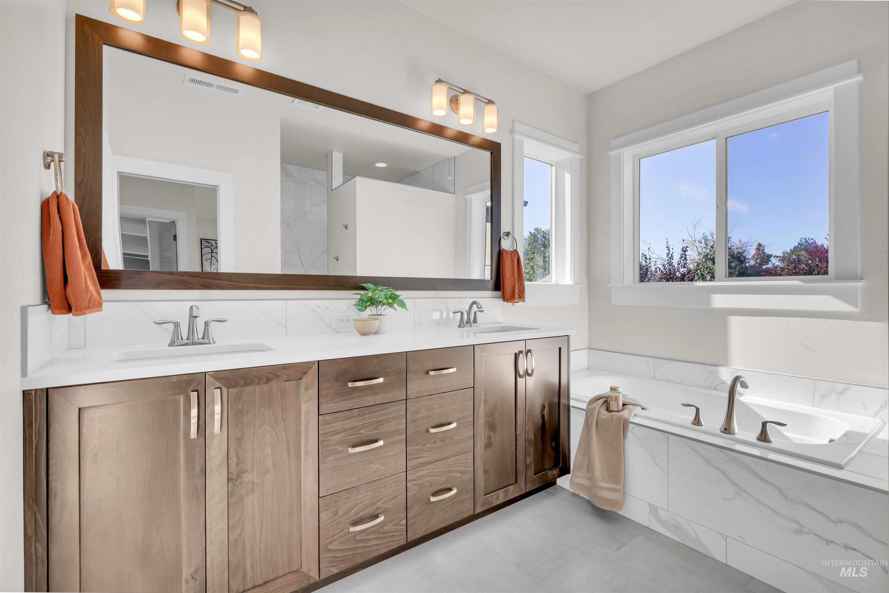 Full bath with double vanity and a garden tub