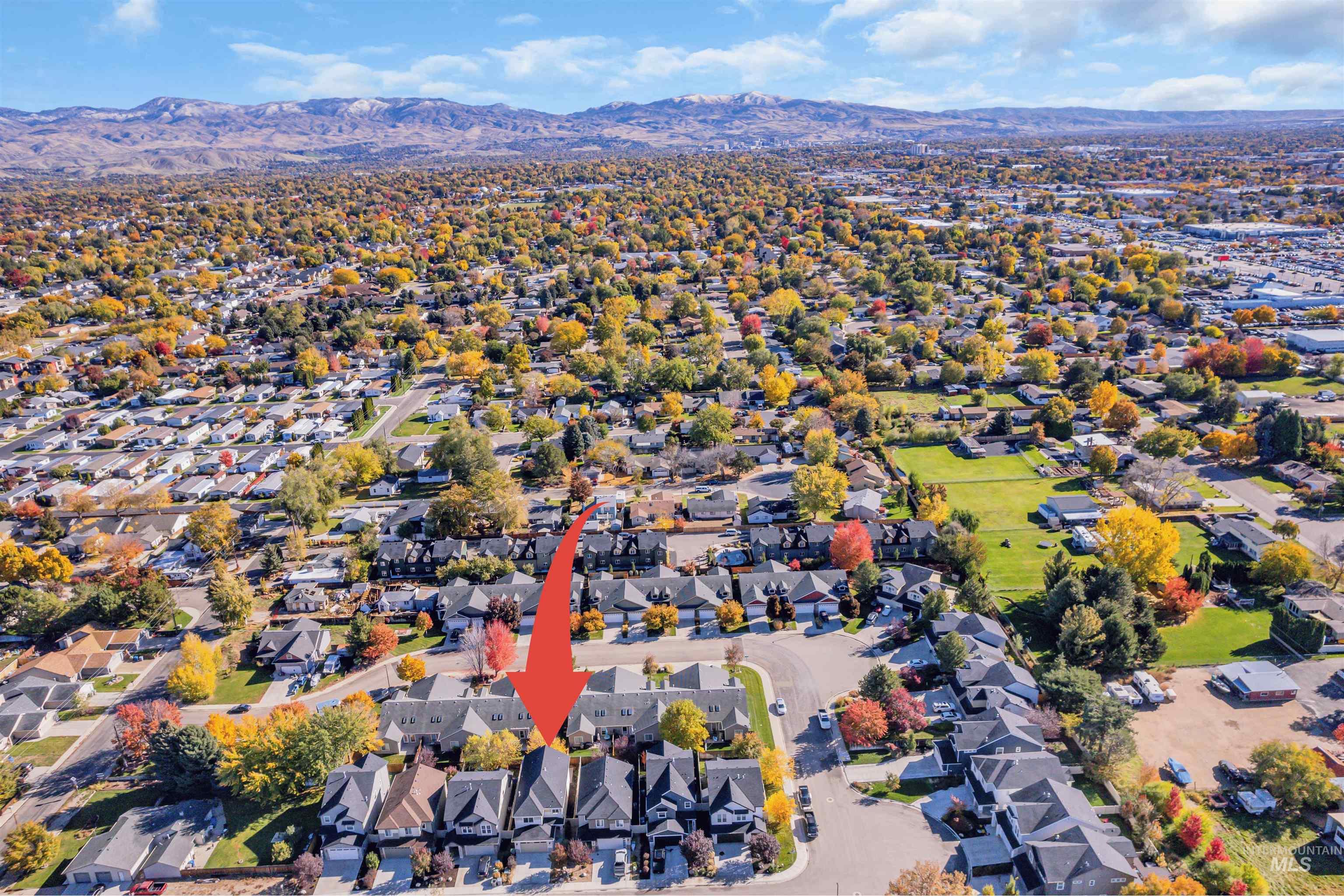 Aerial overview of property's location featuring nearby suburban area and a mountain backdrop