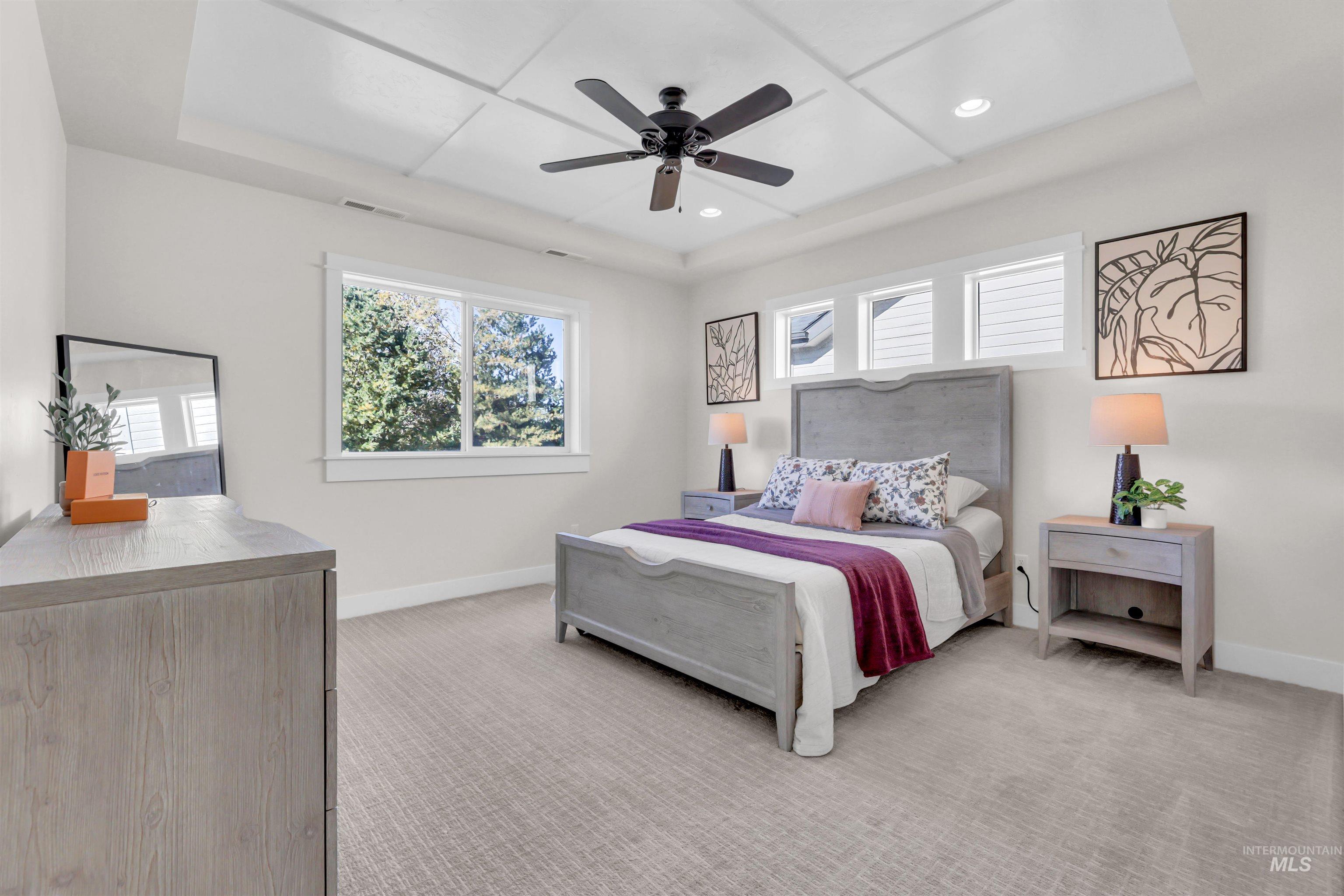 Bedroom with light colored carpet, ceiling fan, recessed lighting, and a tray ceiling