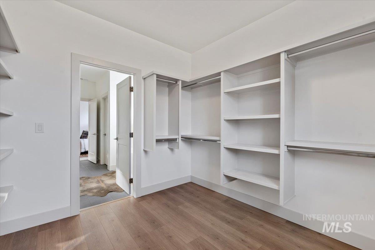 Walk in closet with light wood-style flooring