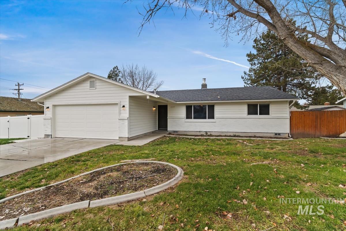 Ranch-style home with a chimney, driveway, an attached garage, and a shingled roof