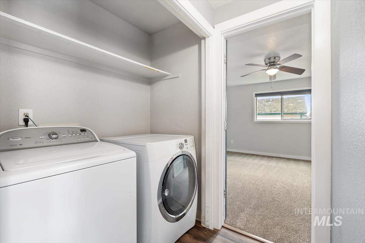 Washroom with washing machine and dryer, ceiling fan, and dark carpet