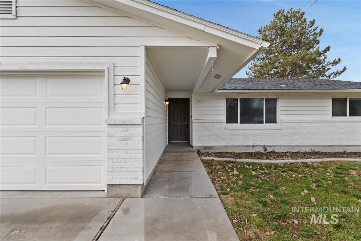 Entrance to property featuring brick siding and a garage