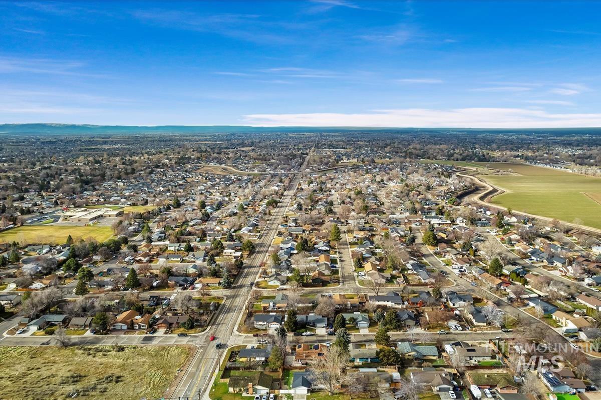Aerial view of property and surrounding area featuring nearby suburban area