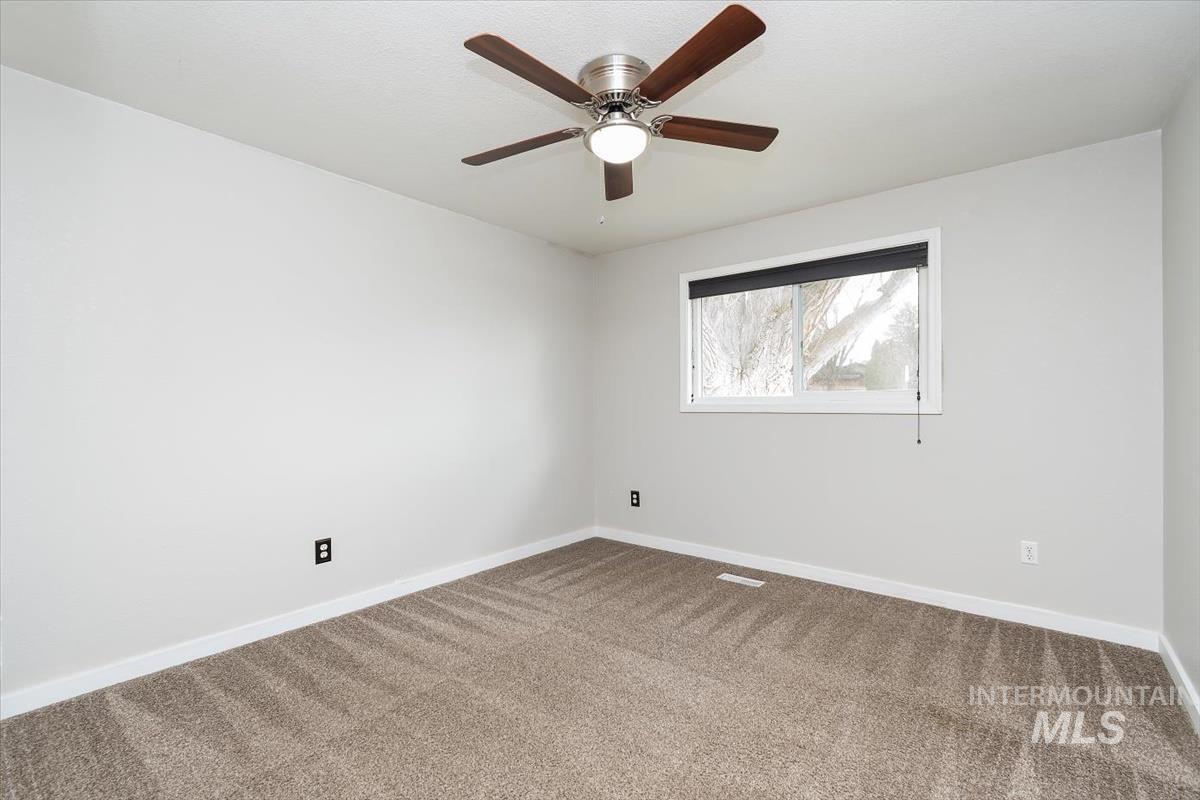 Unfurnished room featuring carpet flooring and a ceiling fan