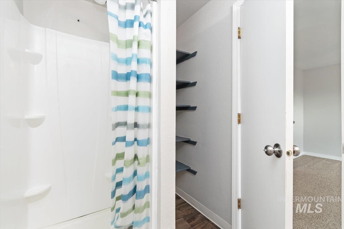 Bathroom with curtained shower and baseboards