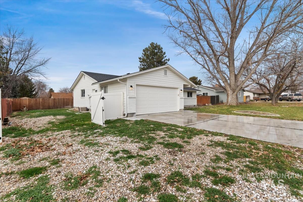 View of side of home with concrete driveway and a garage