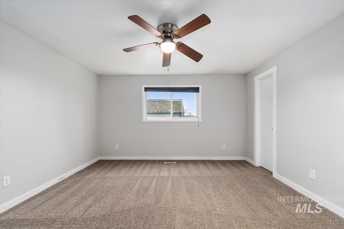Spare room with light carpet and a ceiling fan