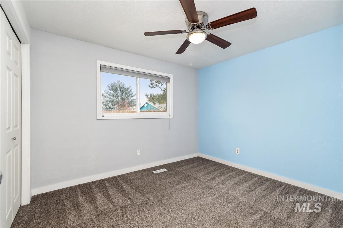 Unfurnished bedroom featuring a closet, carpet flooring, and ceiling fan