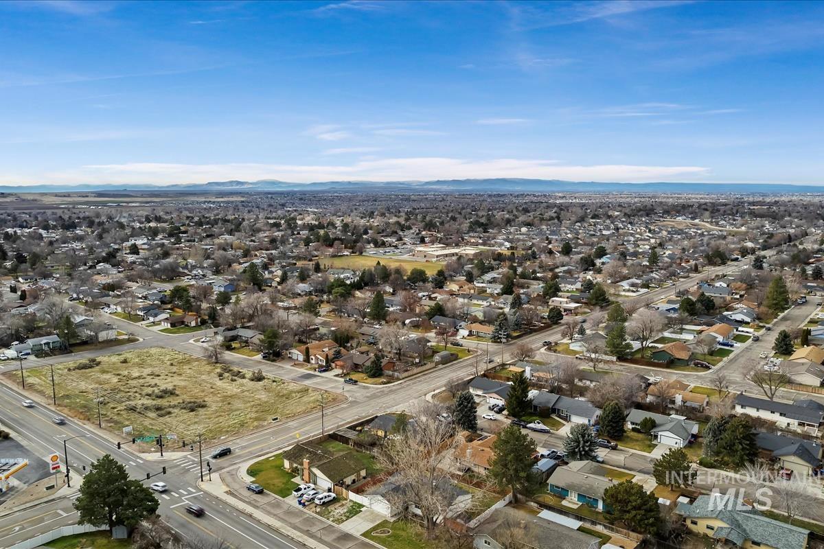Aerial view of property and surrounding area with nearby suburban area and a mountain backdrop