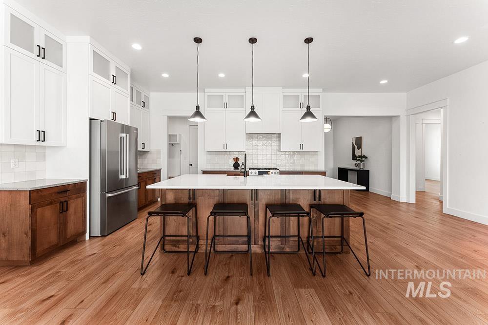 Kitchen featuring high end fridge, tasteful backsplash, a breakfast bar, and recessed lighting