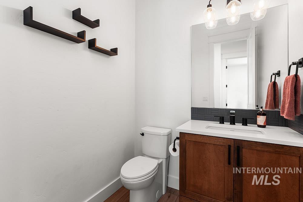 Bathroom featuring vanity, tasteful backsplash, and wood finished floors