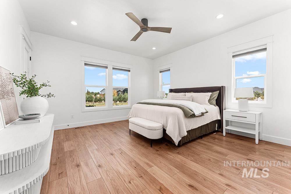 Bedroom featuring light wood-style floors, ceiling fan, and recessed lighting