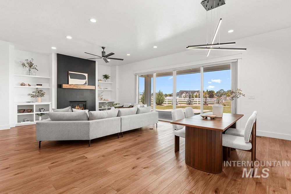 Living area featuring a fireplace, recessed lighting, a ceiling fan, built in features, and light wood-type flooring