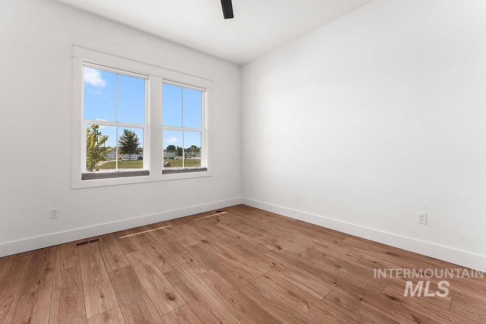 Unfurnished room with light wood-type flooring and ceiling fan