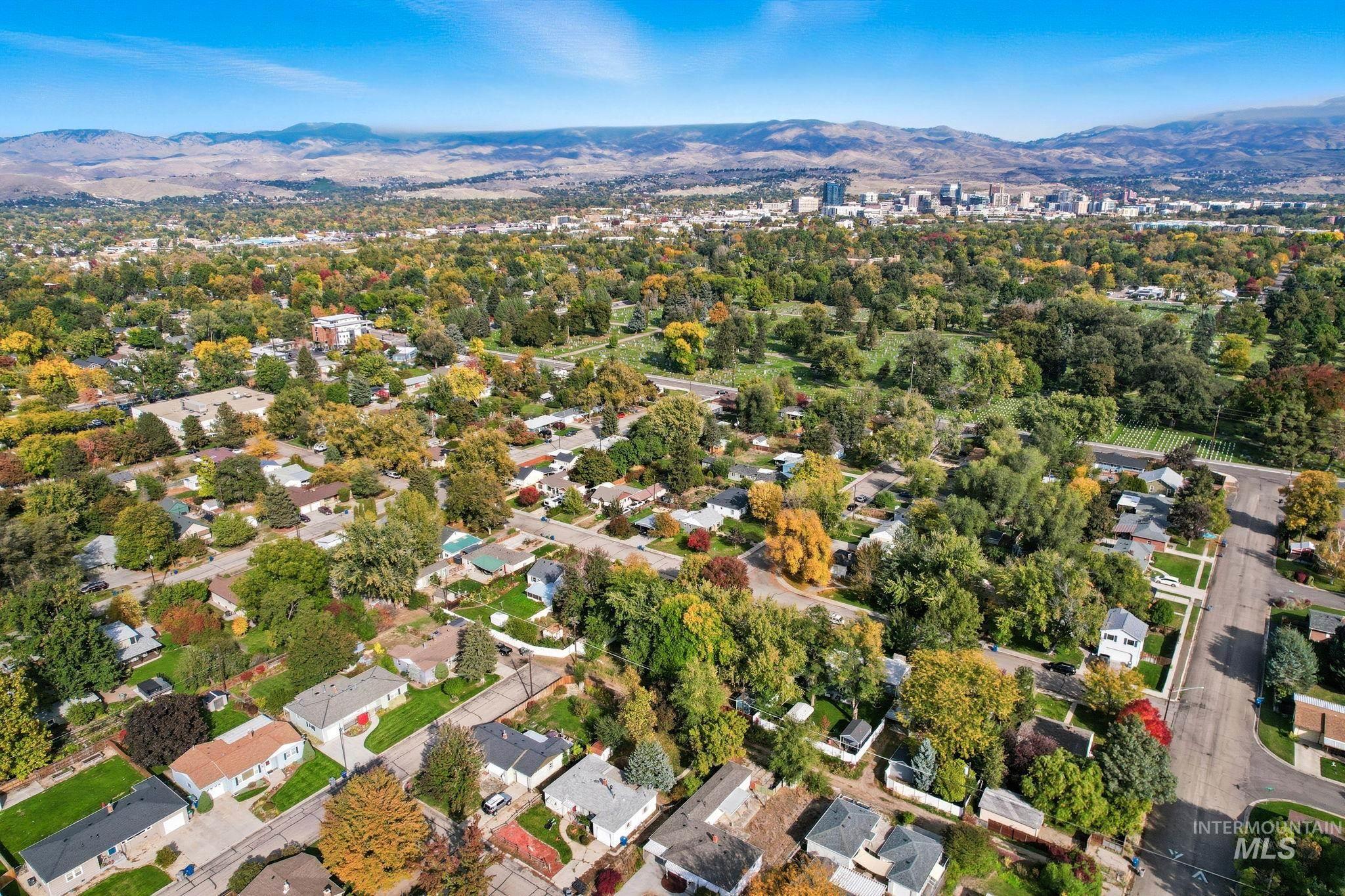 Aerial overview of property's location with a mountainous background and nearby suburban area