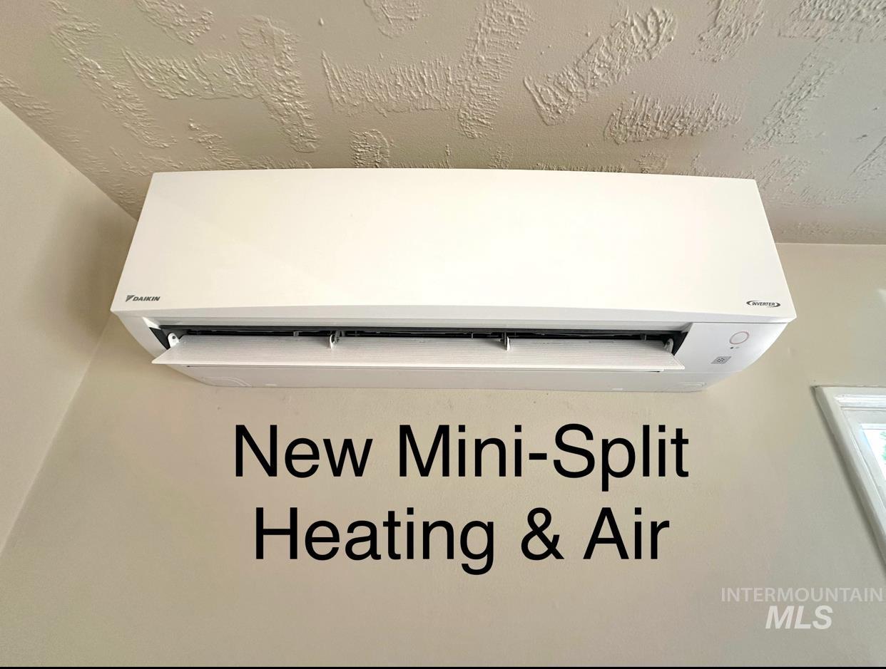 Detailed view of an AC wall unit and a textured ceiling