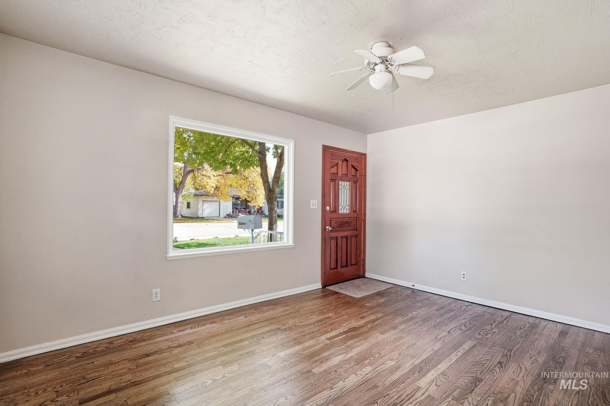Foyer entrance with a textured ceiling, wood finished floors, and a ceiling fan