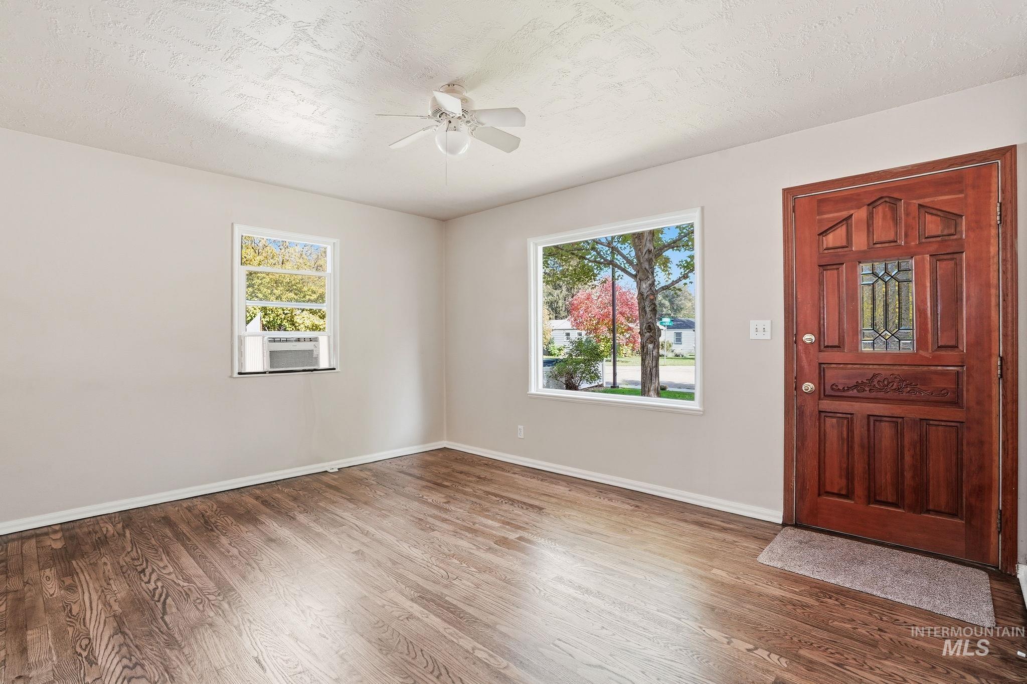Entryway with a textured ceiling, wood finished floors, and ceiling fan