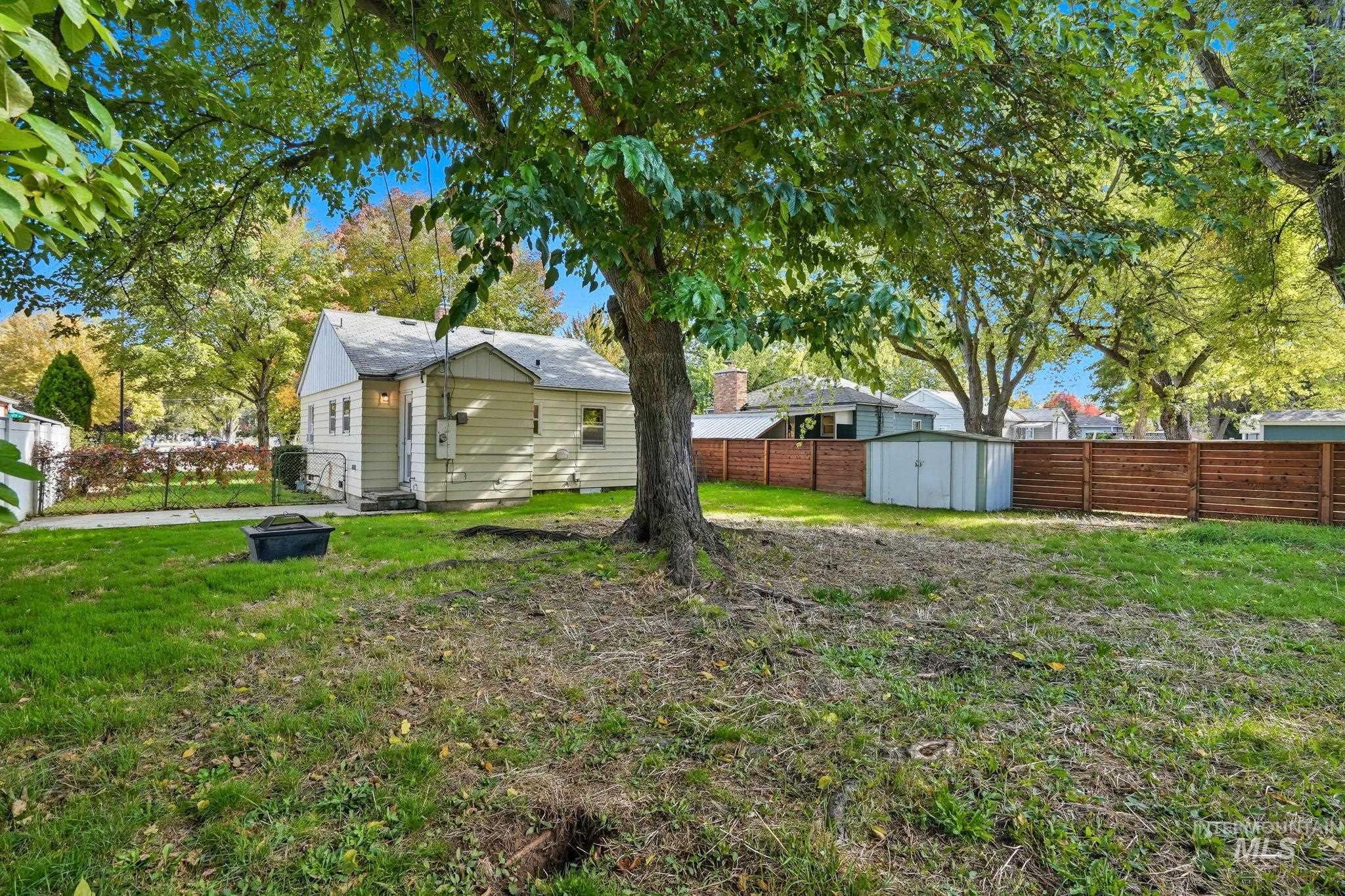 Fenced backyard featuring a shed and an outdoor fire pit