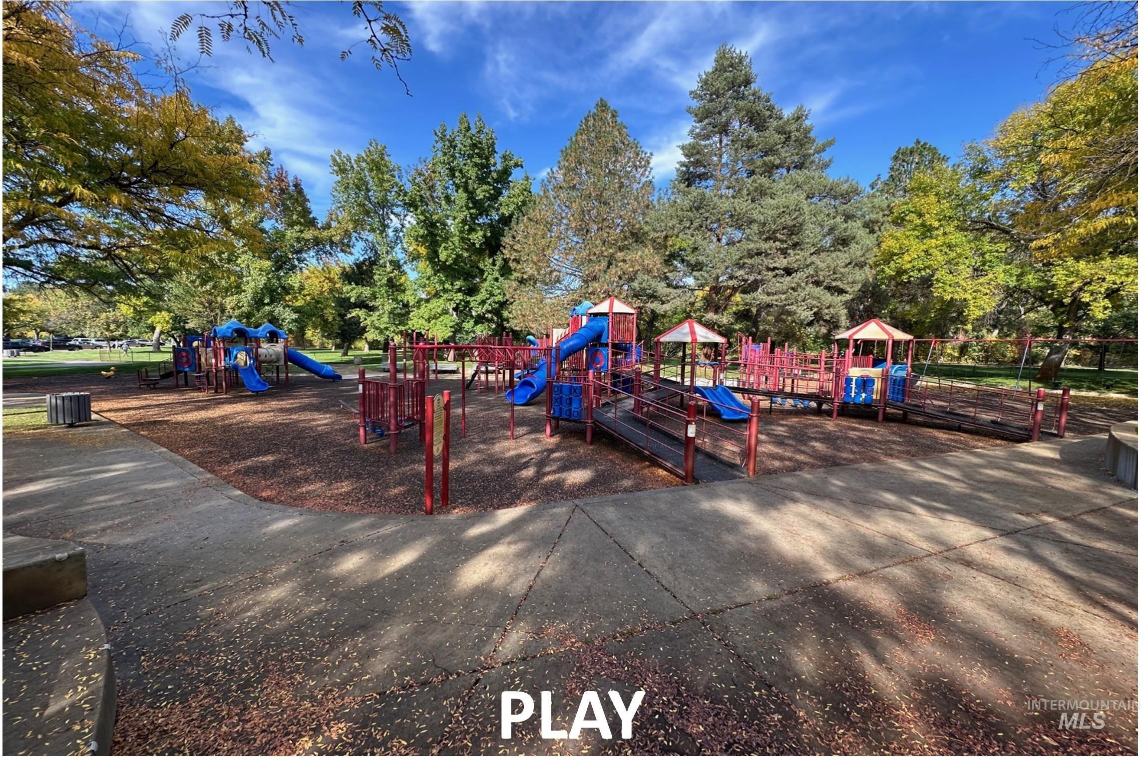 Community jungle gym with view of wooded area